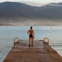 a man standing on a dock looking out at the water